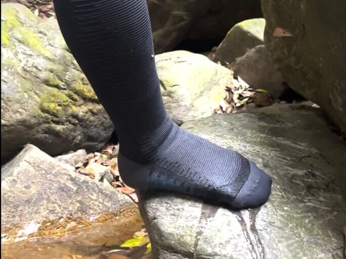Person wearing Konugo waterproof socks standing on wet rocks